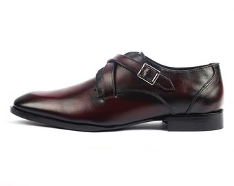 May include: Burgundy leather dress shoes with a single buckle strap.