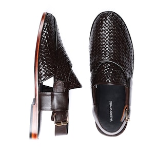 May include: A pair of brown leather sandals with a woven design. The sandals feature a buckle closure and a leather strap around the ankle. The sandals are made by the brand "Valerio Veneto".