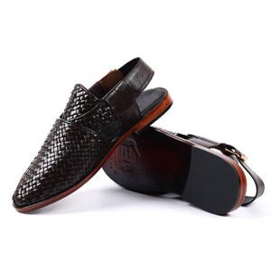 May include: Brown leather sandals with a woven design and a back strap. The sandals have a wooden sole and a black rubber outsole.
