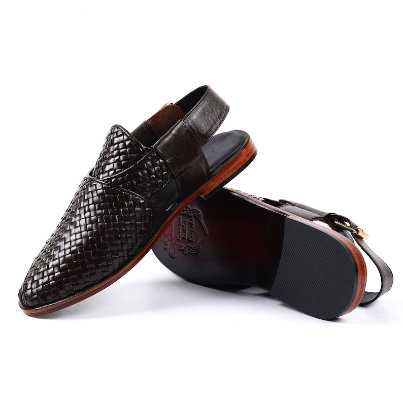 May include: Brown leather sandals with a woven design and a back strap. The sandals have a wooden sole and a black rubber outsole.