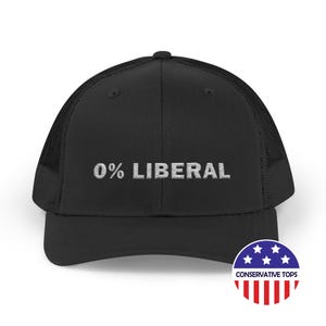 May include: Black trucker hat with the embroidered text "0% LIBERAL". The hat features a mesh back and a curved brim. A circular logo with stars and stripes is visible on the lower right corner.