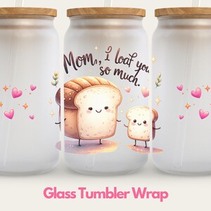 May include: Three white glass tumblers with a wood lid and a straw. The tumblers have a design of two cartoon bread slices with faces and the text "Mom, I loaf you so much."