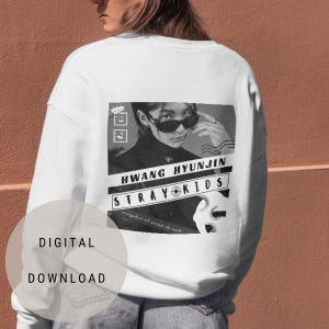 May include: White sweatshirt with a black and white graphic print of a person wearing sunglasses and the text "HWANG HYUNJIN STRAY KIDS" on the back.