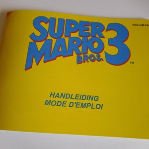 Peut inclure: Manuel d'instructions jaune pour le jeu vidéo Super Mario Bros. 3. Le titre est en lettres bleues et rouges. Le texte "NES-UM-FAH" est dans le coin supérieur droit. Le texte "HANDLEIDING MODE D'EMPLOI" est en bas au centre.