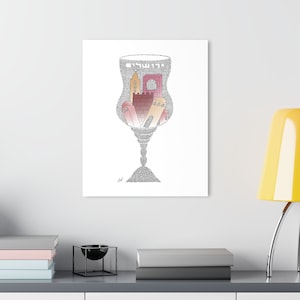 May include: A canvas print featuring a stylized illustration of a wine glass filled with a cityscape. The cityscape includes buildings in shades of pink, orange, and beige. The glass and the text "Jerusalem" are composed of small gray dots.