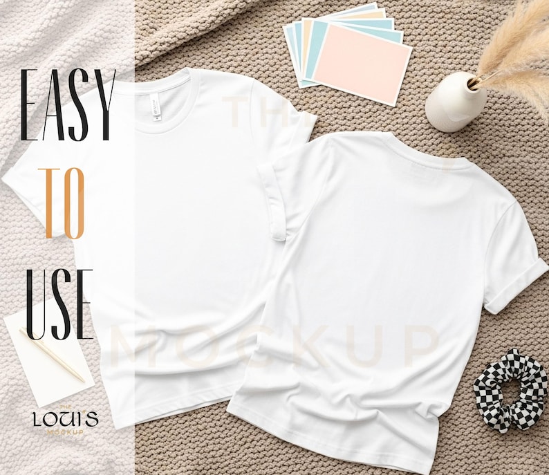 K&ouml;nnte beinhalten: Zwei schlichte, wei&szlig;e T-Shirts mit Rundhalsausschnitt liegen auf einer strukturierten Oberfl&auml;che. Der Text "EASY TO USE" ist sichtbar. Weitere Elemente sind ein Scrunchie, Karten und eine kleine Vase. Mockup-Bild.