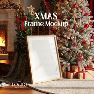May include: A wooden picture frame with a white interior, leaning against a Christmas tree decorated with red ornaments and lights. The text "XMAS Frame Mockup" is visible. Presents are wrapped in brown paper with red ribbons.