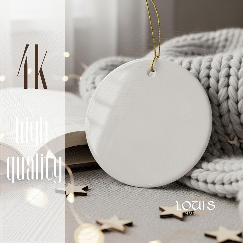 May include: A blank, white ceramic ornament with a gold string for hanging. The ornament is round and smooth, with a glossy finish. The background includes a gray knitted blanket, wooden star decorations, and the text "4k high quality".