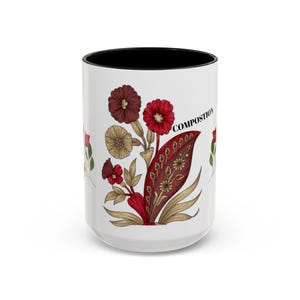 Puede incluir: Taza de cerámica blanca con borde negro que presenta un diseño floral en tonos rojos, marrones y dorados. El diseño incluye hojas y flores estilizadas con la palabra "COMPOSITION" impresa en negro.