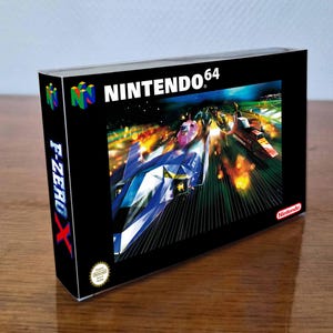 以下が含まれることがあります： F-Zero XのNintendo 64用ビデオゲームの長方形の箱。黒いパッケージにはN64のロゴ、青と赤の文字で書かれたF-Zero Xのタイトル、そしてコースを疾走する未来的なレーシングカーのダイナミックなイラストが描かれています。