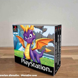 May include: A collection of three PlayStation video game cases featuring Spyro the Dragon on the front cover. The spines are labelled Spyro the Dragon, Spyro 2 Gateway to Glimmer, and Spyro Year of the Dragon. The cases are clear plastic.