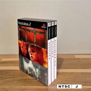 Może przedstawiać: Zestaw gier na konsolę PlayStation 2 zawierający Silent Hill 2, 3 oraz 4: The Room. Przednia okładka przedstawia mroczną, klimatyczną scenę z postacią, a białe grzbiety prezentują logo PlayStation 2 oraz japońskie napisy z tytułami gier.