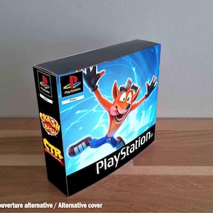 Pode incluir: Uma caixa de jogo retangular para PlayStation com Crash Bandicoot num fundo azul. A lombada exibe o logótipo da PlayStation, o texto PAL e os títulos Crash Bash e CTR Crash Team Racing. A frente inclui o logótipo da PlayStation.