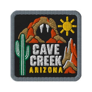 Può includere: Una toppa ricamata quadrata con sfondo nero e bordo grigio. Presenta un cactus saguaro verde, formazioni rocciose arancioni e marrone chiaro, un sole giallo e il testo bianco CAVE CREEK e il testo giallo ARIZONA al centro.