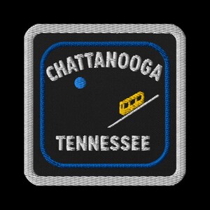 May include: Embroidered patch featuring the text "Chattanooga Tennessee" in white, with a blue border and a yellow cable car design. The patch is square with a white stitched border, perfect for jackets or bags.