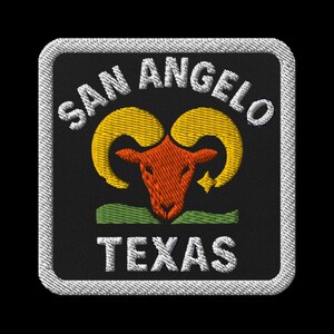 May include: Embroidered patch featuring the words "SAN ANGELO TEXAS" in white, arched over a ram's head. The ram's head is orange with yellow horns, set against a black background with a white border. A green stripe is at the bottom.