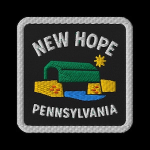 Puede incluir: Parche bordado con las palabras "NEW HOPE PENNSYLVANIA" en blanco. El diseño incluye un puente cubierto verde, estructuras amarillas, un río azul y una estrella amarilla sobre fondo negro, enmarcado por un borde blanco.