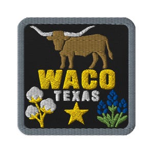 May include: A square embroidered patch with a black background and a grey border. It features a brown longhorn steer, the yellow text WACO, white text TEXAS, a yellow star, a white cotton plant, and a cluster of bluebonnet flowers.
