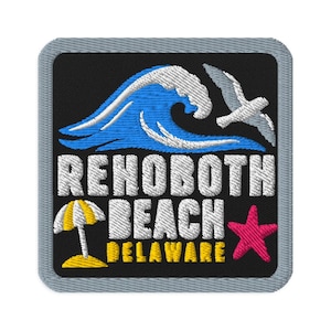 Puede incluir: Un parche bordado cuadrado con borde gris sobre fondo negro. Presenta una ola azul, una gaviota blanca, una sombrilla amarilla y blanca, una estrella de mar rosa y el texto blanco REHOBOTH BEACH y el texto amarillo DELAWARE.