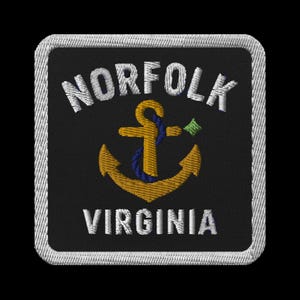 May include: Embroidered patch featuring the words "NORFOLK VIRGINIA" in white, arched above and below a gold anchor with a blue rope. A small green emblem is to the right of the anchor. The patch has a black background and a white stitched border.