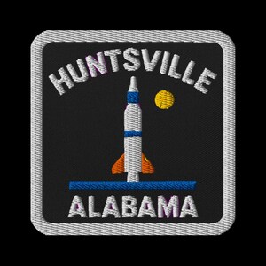 May include: Embroidered patch featuring a rocket ship design with the text "HUNTSVILLE ALABAMA". The rocket is white, blue, and orange, with a yellow sun. The patch is square with a white border.