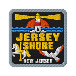 Peut inclure: Un écusson brodé carré avec une bordure grise sur fond noir. Il représente un phare avec des faisceaux jaunes, des vagues bleues, un cheval de carrousel jaune, une mouette blanche aux ailes orange et le texte JERSEY SHORE NEW JERSEY.