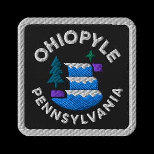 Puede incluir: Parche bordado con el texto "Ohiopyle Pennsylvania" en blanco, curvado alrededor de un diseño central. El diseño incluye una cascada azul, árboles verdes y detalles morados sobre un fondo negro, con un borde blanco.