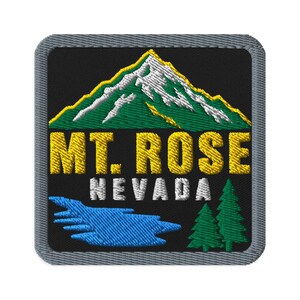 May include: A square embroidered patch with a black background featuring a green and white mountain with a yellow outline. Below the mountain, the yellow text reads MT. ROSE, followed by the white text NEVADA, a blue lake, and two green pine trees.