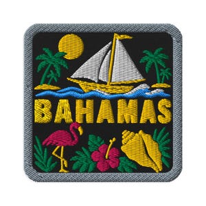 May include: A square embroidered patch with a black background and a gray border. It features a yellow sun, a white sailboat on blue waves, green palm trees, a pink flamingo, a red hibiscus flower, a yellow seashell, and the text BAHAMAS in yellow.