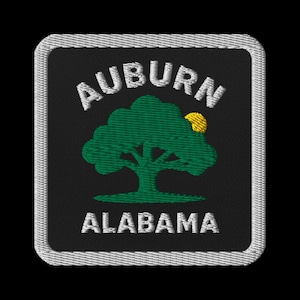 May include: Embroidered patch with the words "AUBURN ALABAMA" in white, above and below a green tree with a yellow sun. The patch is square with a white border and a black background.