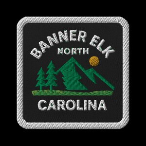 Puede incluir: Parche bordado con el texto "BANNER ELK NORTH CAROLINA" en blanco, arqueado alrededor de una escena de montaña verde con árboles y un sol amarillo. El parche tiene un fondo negro y un borde cosido blanco.
