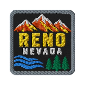 May include: A square embroidered patch with a gray border on a black background. It features orange and white mountain peaks above the yellow text RENO and white text NEVADA. Below the text are blue wavy lines and three green pine trees.