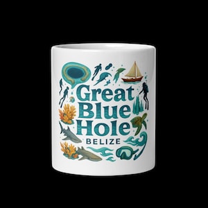 May include: White ceramic mug featuring the words "Great Blue Hole Belize" in teal, surrounded by illustrations of divers, sharks, coral, a sailboat, and a sea turtle. The design is a vibrant depiction of marine life.