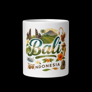 Könnte beinhalten: Weißer Keramikbecher mit dem Wort "Bali" in dekorativer Schrift, umgeben von Illustrationen indonesischer Landschaften. Das Design umfasst einen Berg, Tempel, Blumen und das Wort "Indonesia".