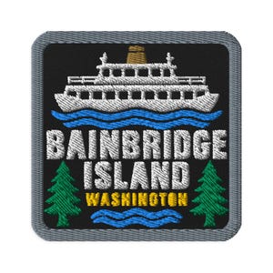 May include: A square embroidered patch with a black background and a gray border. It features a white ferry boat above blue waves, the white text BAINBRIDGE ISLAND, the yellow text WASHINGTON, and two green pine trees on the sides.