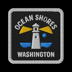 May include: Embroidered patch featuring a lighthouse with yellow beams, blue water, and a blue sphere on a black background. The text "OCEAN SHORES WASHINGTON" is arched above and below the lighthouse in white.