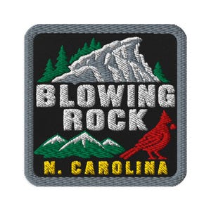Op de afbeelding: Een vierkante geborduurde patch met een zwarte achtergrond en een grijze rand. Het toont een witte bergtop, groene dennenbomen en een rode kardinaalvogel. De tekst luidt BLOWING ROCK in het wit en N. CAROLINA in het geel.