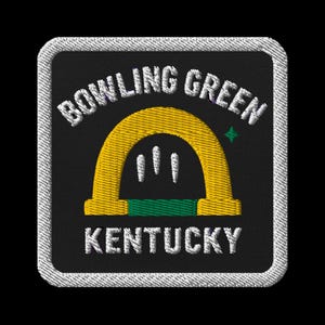 May include: Embroidered patch featuring the words "BOWLING GREEN KENTUCKY" in white, arched over a yellow and green design. The patch has a black background and a white stitched border. A small green star is visible.