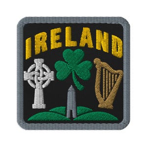 May include: A square embroidered patch with a black background and a gray border. The word IRELAND is stitched in yellow at the top. Below, it features a white Celtic cross, a green shamrock, and a gold harp above green hills.