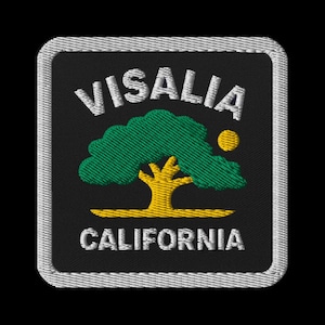 May include: Embroidered patch with the words "VISALIA" and "CALIFORNIA" in white, above and below a green tree with a yellow trunk and a yellow sun. The patch has a black background and a white border.