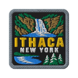 Könnte beinhalten: Ein quadratischer gestickter Aufnäher mit schwarzem Hintergrund, der einen Wasserfall über braunen Klippen mit grünen Bäumen zeigt. Der Text ITHACA ist gelb und NEW YORK weiß. Ein blauer Fluss und grüne Tannen sind unten zu sehen.