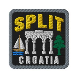 Puede incluir: Un parche bordado cuadrado con fondo negro y borde gris. El texto amarillo dice SPLIT y el texto blanco CROATIA. Presenta un velero blanco sobre olas azules, un arco de piedra blanco y un árbol de hoja perenne de color verde.