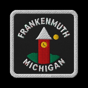 Puede incluir: Parche bordado con el texto "Frankenmuth Michigan" en blanco. Presenta una torre roja con una esfera de reloj amarilla, un tejado blanco y un punto amarillo. El parche tiene un borde blanco y un fondo negro.