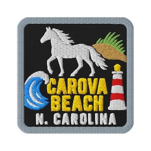 Puede incluir: Un parche bordado cuadrado con borde gris sobre fondo negro. Presenta un caballo blanco, una ola azul, una duna color canela con hierba verde y un faro rojo y blanco. El texto dice CAROVA BEACH N. CAROLINA en letras amarillas y blancas.