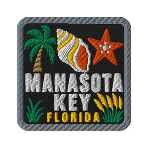 Könnte beinhalten: Ein quadratischer gestickter Aufnäher mit schwarzem Hintergrund und grauem Rand. Er zeigt eine grüne Palme, eine gelb-weiße Muschel und einen orangefarbenen Seestern. Der Text MANASOTA KEY FLORIDA ist in Weiß und Gelb aufgestickt.