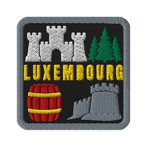 Peut inclure: Un écusson brodé carré à fond noir avec une bordure grise. Il représente un château blanc, trois sapins verts, le texte jaune LUXEMBOURG, un tonneau rouge à cerclages jaunes et une tour en pierre grise avec un pan de mur.