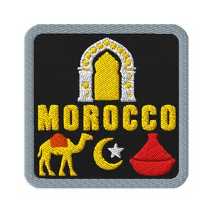 May include: A square embroidered patch with a black background and a grey border. It features a white and yellow arched doorway, the yellow text MOROCCO, a yellow camel with a red saddle, a yellow crescent moon with a white star, and a red tagine.