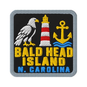 Peut inclure: Un écusson brodé carré avec une bordure grise sur fond noir. Il représente un pygargue à tête blanche, un phare rouge et blanc, et une ancre jaune au-dessus de vagues bleues. Le texte indique BALD HEAD ISLAND en jaune et N. CAROLINA en bleu.