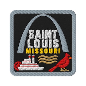 May include: A square embroidered patch with a gray border on a black background. It features a light gray Gateway Arch, white text reading SAINT LOUIS, yellow text reading MISSOURI, a white steamboat, tan wavy lines, and a red cardinal bird.