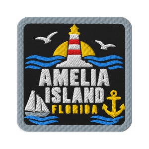 Puede incluir: Un parche bordado cuadrado con borde gris que presenta un faro con rayas rojas y blancas, dos gaviotas blancas, olas azules, un velero blanco, un ancla amarilla y el texto AMELIA ISLAND FLORIDA en hilo blanco y amarillo.